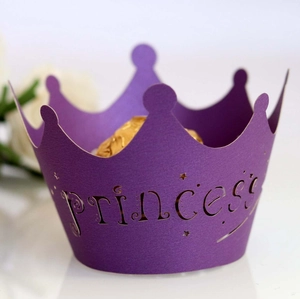 Detail of laser-cut purple princess crown cupcake wrapper with stars and intricate lace