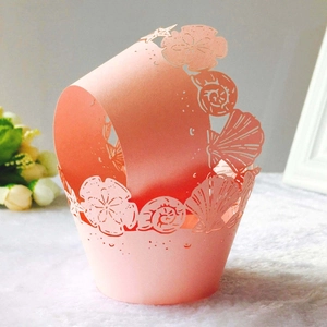 Detailed laser-cut ocean shell and starfish patterns on pink cupcake wrappers