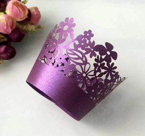 Detail of purple pearlescent paper cupcake wrappers with intricate laser-cut floral patterns