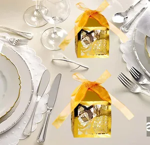 Détail du motif floral découpé au laser sur boîte cadeau dorée avec ruban orange