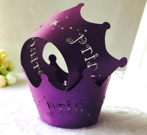 Detail of laser-cut purple paper cupcake wrappers with Prince and Princess crown design