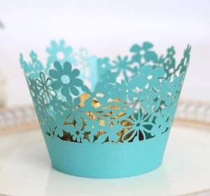 Close-up of turquoise laser-cut cupcake wrapper with intricate floral hollow design
