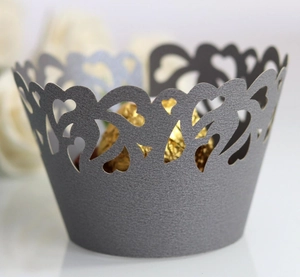 Close-up of laser-cut heart pattern on silver-grey cupcake wrapper with pearl finish