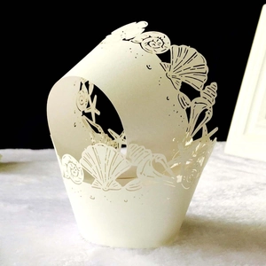 Laser-cut shell and starfish pattern cupcake wrappers in cream white paper decoration
