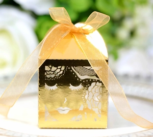 Détail macro d'une boîte cadeau rose découpée au laser avec miroir doré et ruban