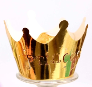 Macro view of gold Princess laser-cut crown cake topper with shiny metallic finish
