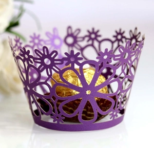 Macro detail of laser-cut purple flower cupcake wrapper with intricate floral patterns