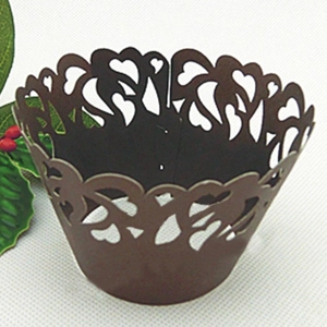 Macro view of brown laser-cut heart pattern lace cupcake liners for wedding party