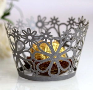 Close-up of grey laser-cut cupcake wrapper featuring delicate daisy floral patterns