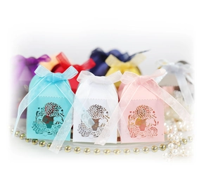 Laser-cut floral wedding favor boxes with satin ribbons in blue, white, and pink