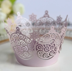Detail of laser-cut crown cupcake wrapper with delicate snowflake and scroll patterns
