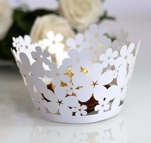 Laser-cut white cupcake wrapper with floral patterns surrounding a golden chocolate ball
