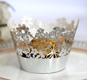 Close-up of silver hollow lace cake wrappers with laser-cut floral patterns for weddings