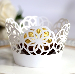 Intricate laser-cut white lace cake wrappers with elegant floral hollow patterns for weddings