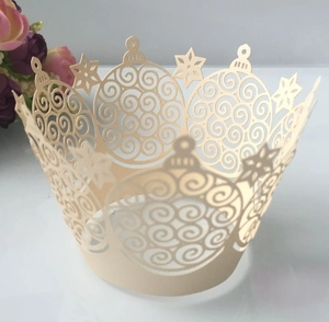 Detail view of laser-cut crown cupcake wrapper with intricate lace and snowflake patterns