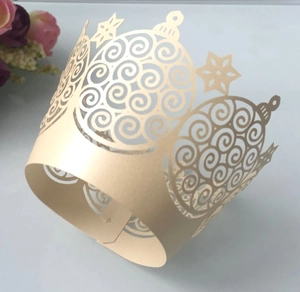 Close-up of laser-cut champagne pearl paper cupcake wrappers with snowflake patterns