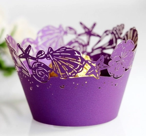 Detail of purple laser-cut cupcake wrapper with ocean shell and starfish patterns