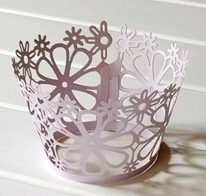 Detail view of lavender laser-cut floral paper cupcake wrappers for wedding decor