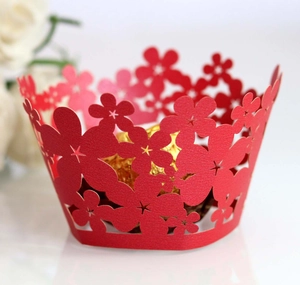 Macro detail of red laser-cut floral pattern cupcake wrappers with hollow design