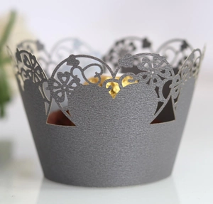 Close-up of laser-cut grey pearlescent cupcake wrappers with heart and floral hollow patterns