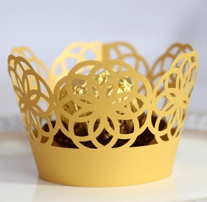 Detailed laser-cut gold cupcake wrapper with intricate geometric floral hollow pattern