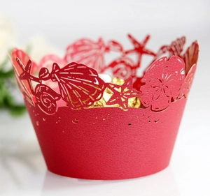 Detailed laser-cut red cupcake wrappers with seashell patterns and chocolate inside