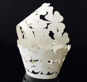 Macro shot of white laser-cut cake wrappers with heart and clover hollow patterns