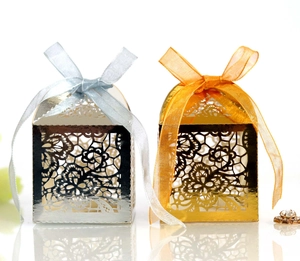 Elegant laser-cut floral wedding candy boxes in gold and silver with organza ribbons