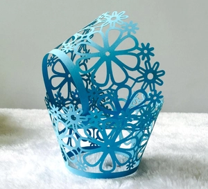 Detailed laser-cut sky blue cupcake wrappers with hollow floral pattern for party decoration