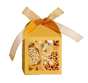 Motifs de roses découpés au laser sur une boîte à cadeaux dorée avec un nœud en satin