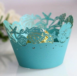 Detailed laser-cut sea star and shell patterns on teal pearlescent cupcake wrappers
