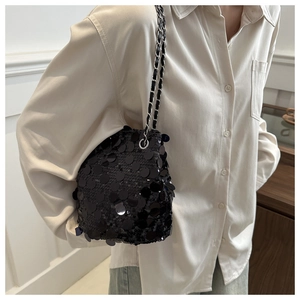 Détail du sac seau noir à paillettes avec bandoulière en chaîne de métal argenté et cuir