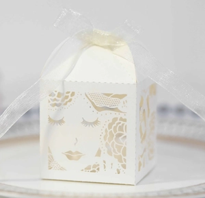 Vue macro de la boîte à dragées blanche découpée au laser avec ruban blanc et motif floral