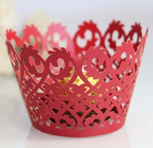 Dettaglio di pirottini per cupcake rossi tagliati al laser con eleganti motivi in pizzo