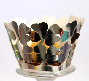 Close-up of silver laser-cut four-leaf clover cupcake wrapper with a mirror finish
