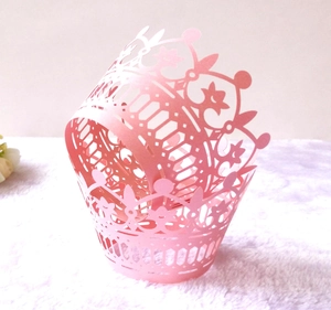 Pink laser-cut cupcake wrappers with elegant crown lace design for party decorations