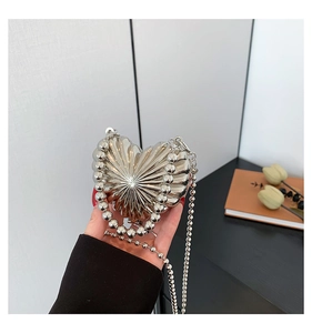 Detail of silver heart-shaped mini bag with textured pleats and beaded handle