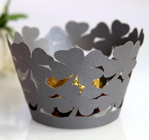Detail of dark green clover laser-cut cupcake wrappers with elegant hollow patterns
