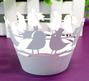 Intricate laser-cut white bird cupcake wrappers for romantic weddings and parties