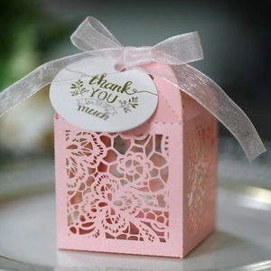 Detailed laser-cut pink wedding favor box with pearl texture and silk ribbon