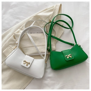 Detail of white and green underarm bags with metal bow buckle and smooth texture