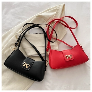 Detail of red and black crescent shoulder bags with elegant gold bow metal clasps