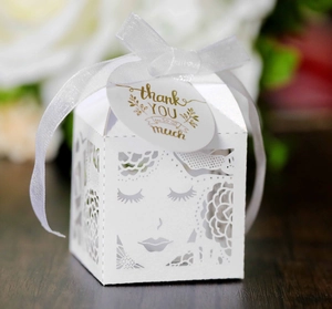 Détail boîte à bonbons florale découpée au laser avec ruban blanc et étiquette dorée