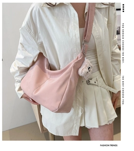 Pink crescent hobo bag with adjustable strap and cute teddy bear charm detail