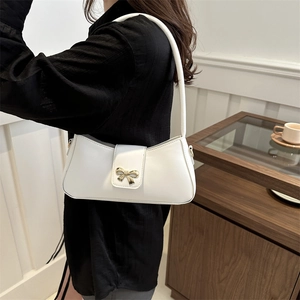 Elegant white faux leather underarm bag with a gold bow accent and slim shoulder strap