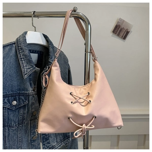 Pink leather shoulder bag detail with cross-lacing and silver decorative chain strap
