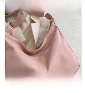 Detail shot of a pink hobo tote bag featuring vertical stitching and textured surface