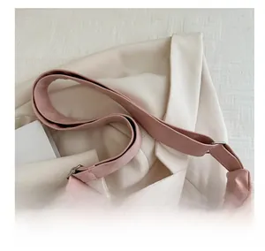 Detail of adjustable wide pink leather strap with silver metal buckle on a tote bag