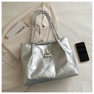 Detail of silver quilted tote bag with metallic leather finish and pearl chain ornament