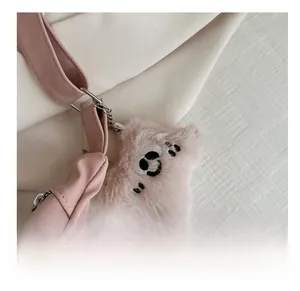 Detailed view of pink plush star charm with embroidered face and metal chain strap